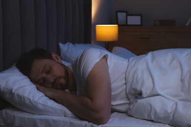 Handsome man sleeping in bed at night