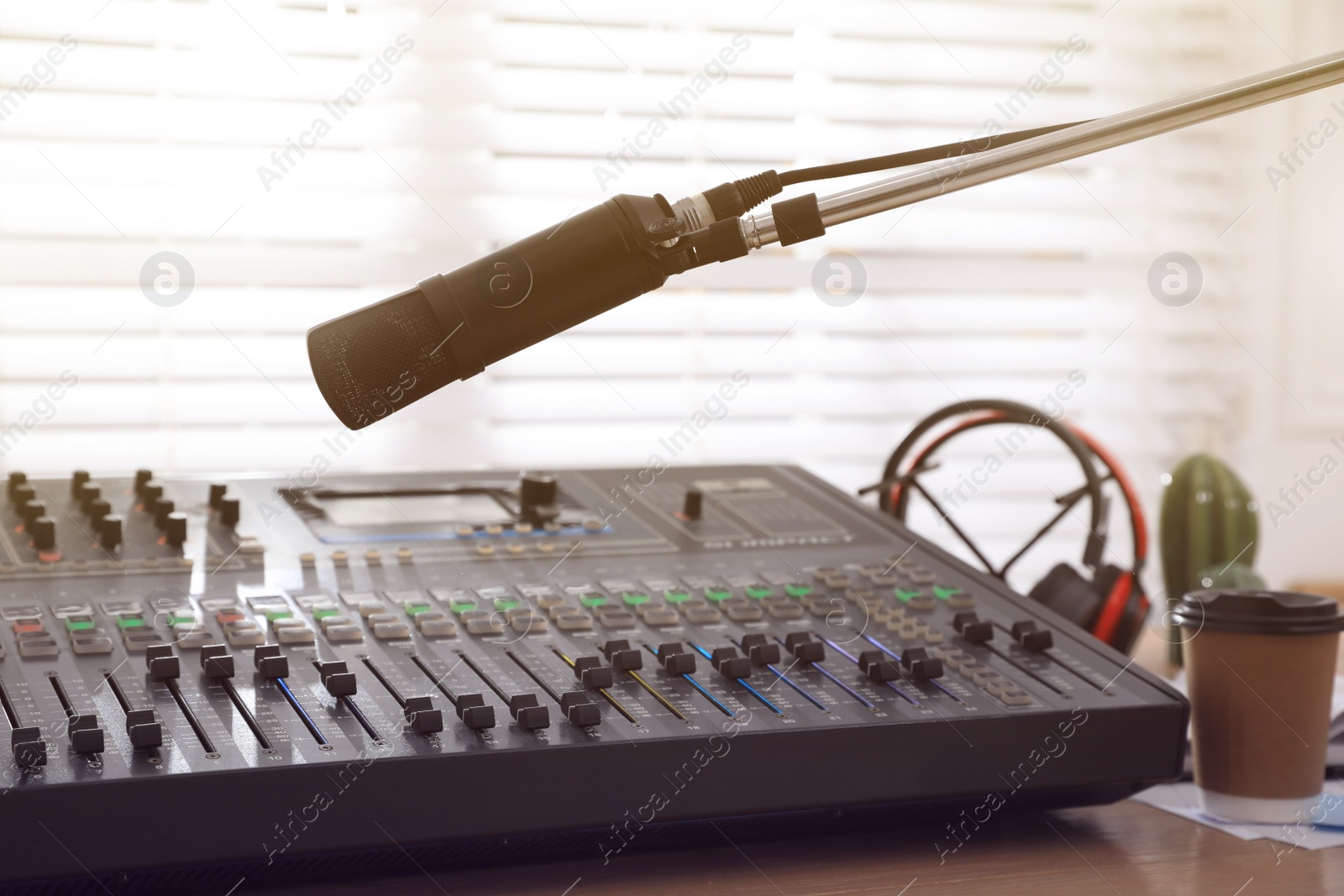 Photo of Microphone near professional mixing console in radio studio
