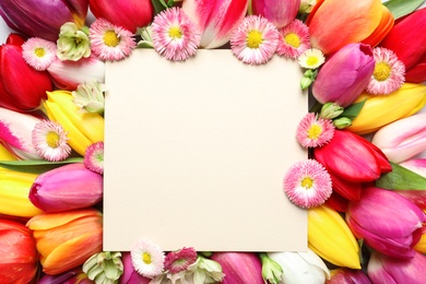 Photo of Beautiful spring flowers and blank card, top view. Space for text