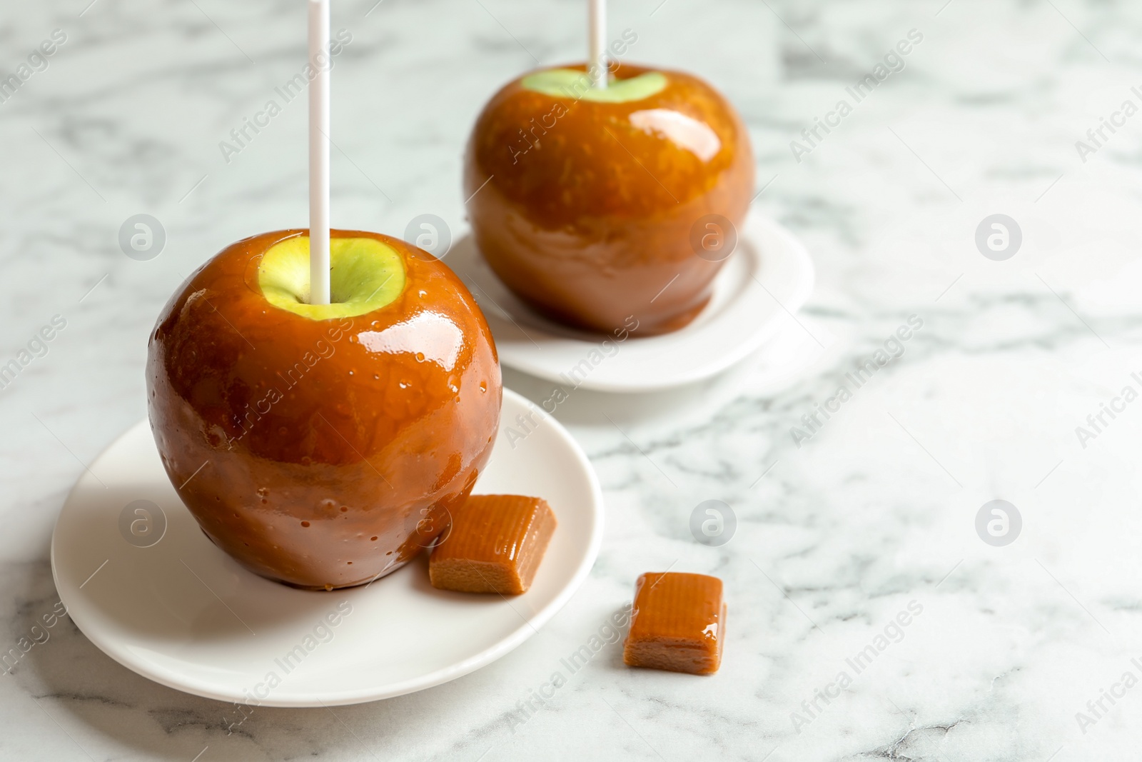 Photo of Delicious green caramel apples on marble table