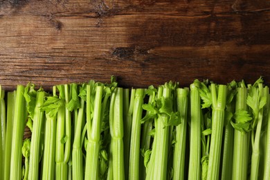 Photo of Fresh ripe green celery on wooden table, flat lay. Space for text