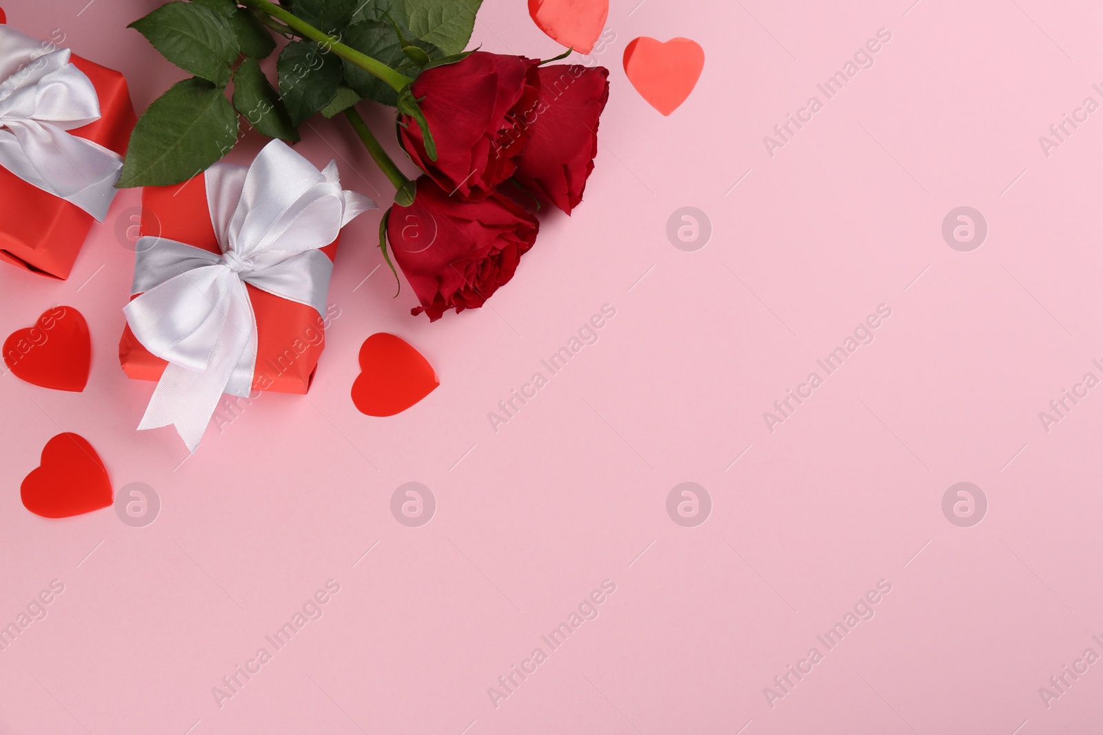 Photo of Beautiful gift boxes, roses and hearts on pink background, flat lay with space for text. Valentine's day celebration