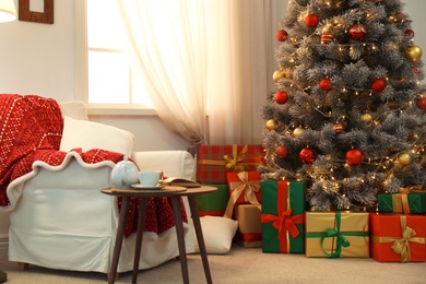 Stylish room interior with beautiful Christmas tree and gift boxes