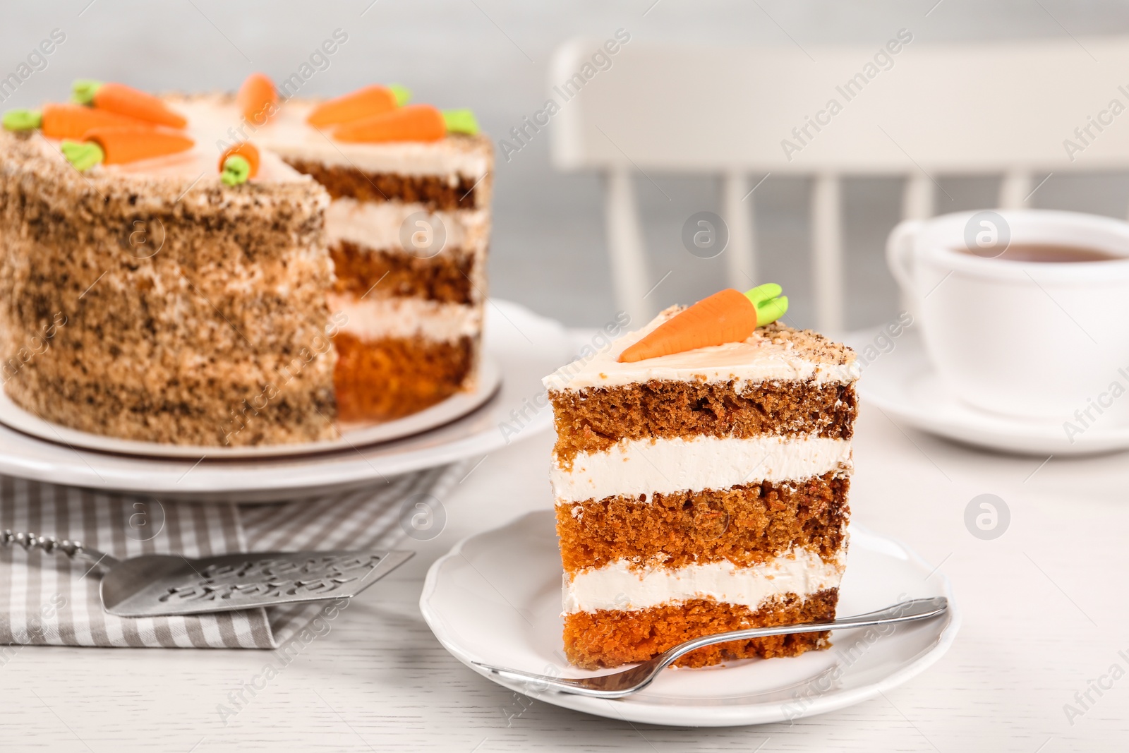 Photo of Sweet carrot cake with delicious cream on white wooden table indoors