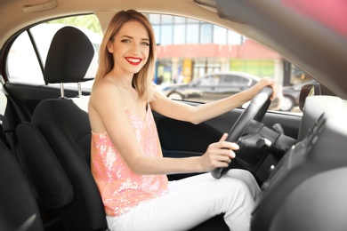 Photo of Young woman on driver's seat of car