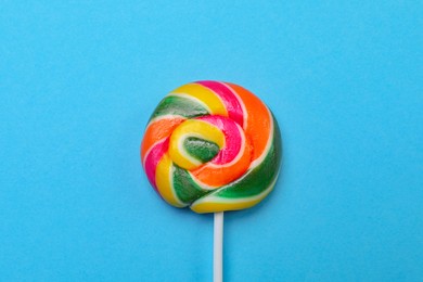 Photo of Sweet colorful lollipop on light blue background, top view