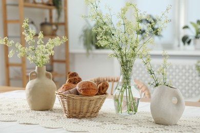 Fresh pastries and beautiful flowers on table in stylish dining room