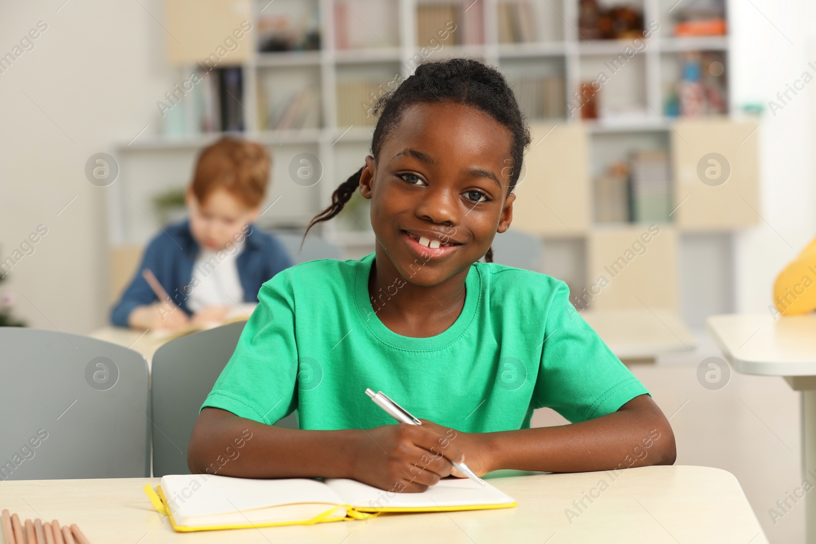 Photo of Portrait of smiling little boy studying in classroom at school