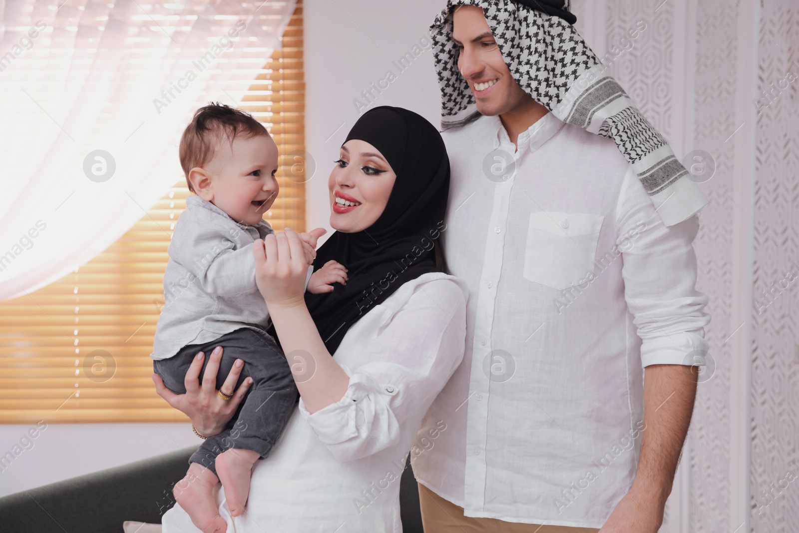 Photo of Happy Muslim family with little son at home