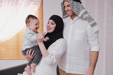 Photo of Happy Muslim family with little son at home