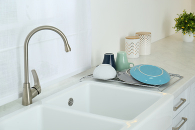 Clean dishes drying on rack in modern kitchen