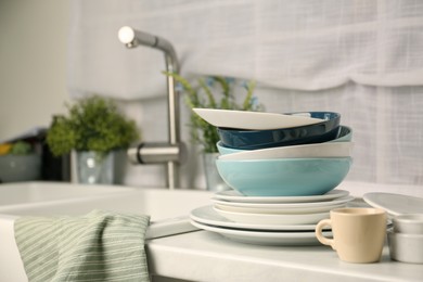 Photo of Set of clean dishware on white countertop in kitchen, space for text