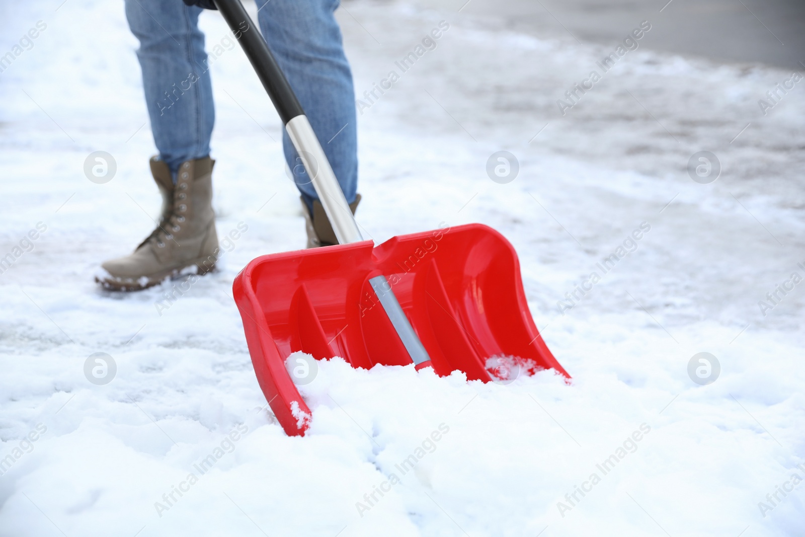 Photo of Person shoveling snow outdoors on winter day, closeup