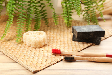 Photo of Natural toothbrushes made with bamboo on wooden table