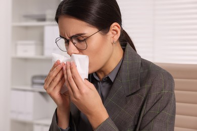 Photo of Woman with tissue coughing indoors. Cold symptoms