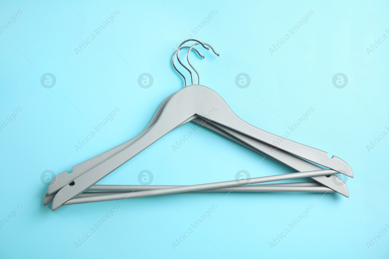 Photo of Flat lay composition with empty hangers on color background