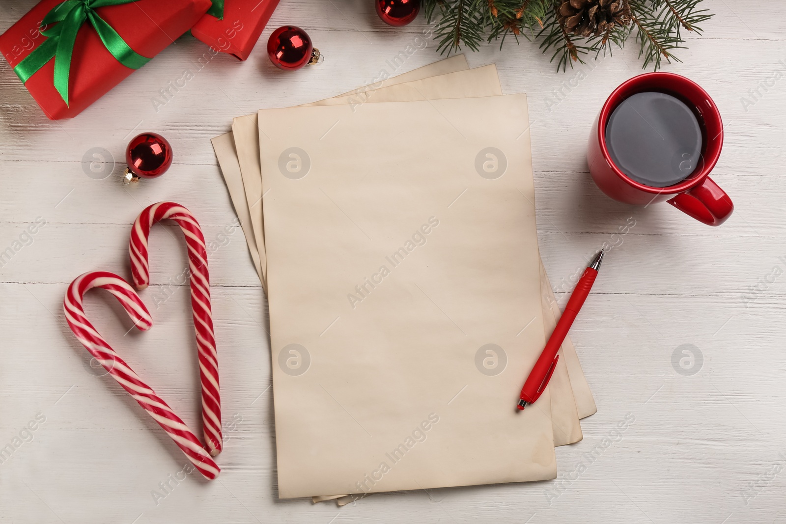 Photo of Flat lay composition with paper and Christmas decor on white wooden table. Writing letter to Santa Claus