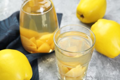 Delicious quince drink and fresh fruits on grey table, closeup