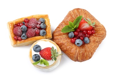 Fresh delicious puff pastries with sweet berries on white background, top view