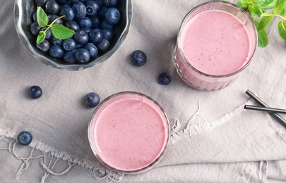 Flat lay composition with healthy detox smoothie and blueberries on grey background