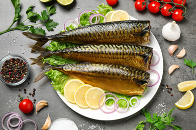 Flat lay composition with tasty smoked fish on grey table