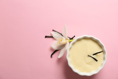 Photo of Vanilla pudding, sticks and flower on color background