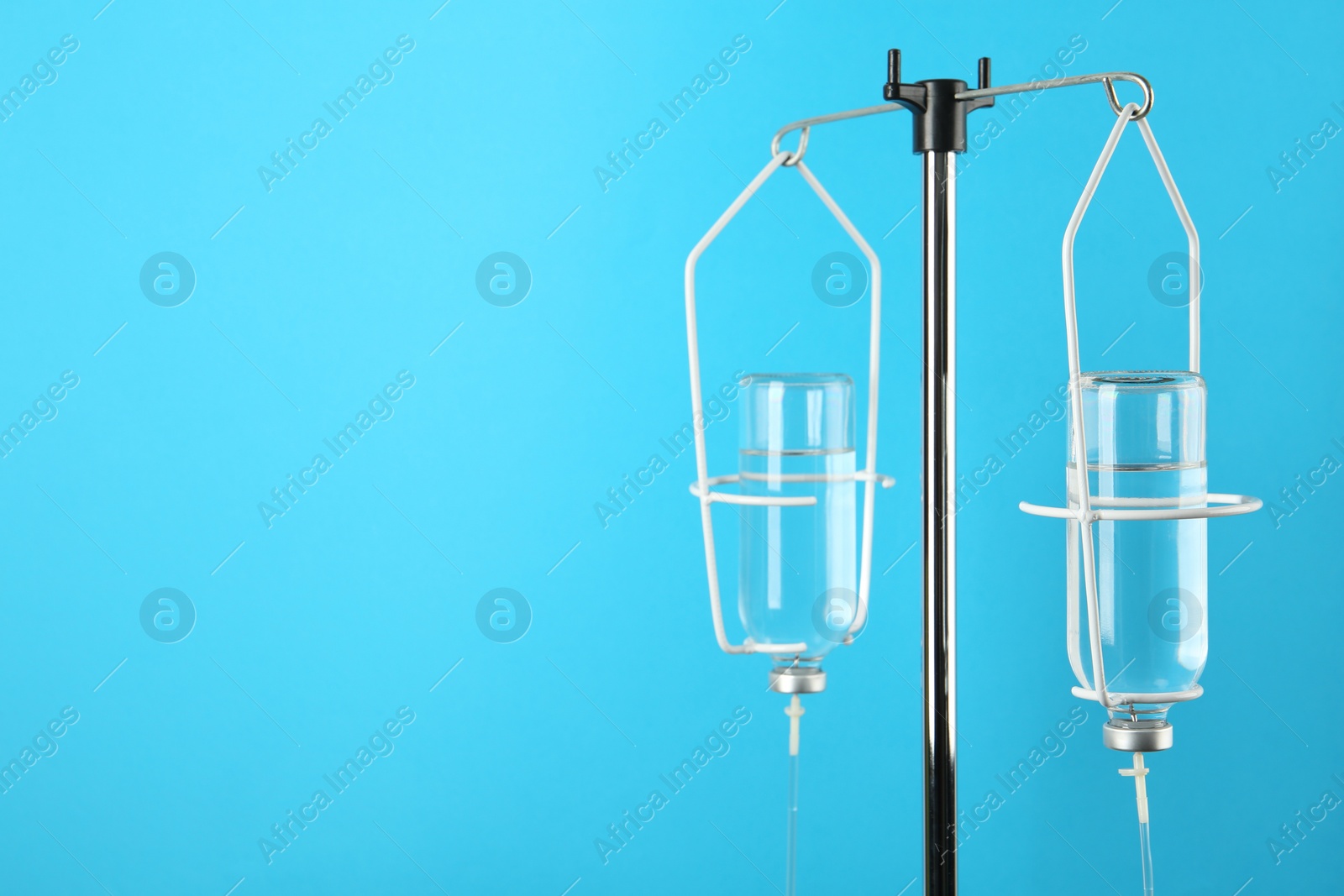 Photo of IV infusion set on light blue background. Space for text