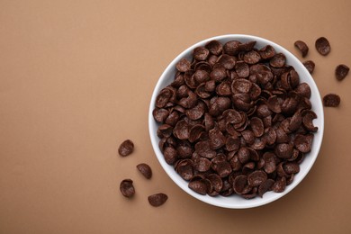 Breakfast cereal. Chocolate corn flakes in bowl on brown table, top view. Space for text