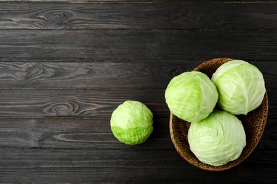 Photo of Ripe white cabbage on black wooden table, flat lay. Space for text