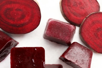 Photo of Frozen beetroot puree cube and fresh beetroot on white background, top view