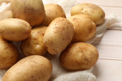 Raw fresh potatoes on light wooden table