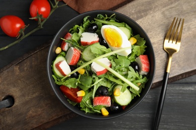 Tasty crab stick salad served on grey wooden table, flat lay