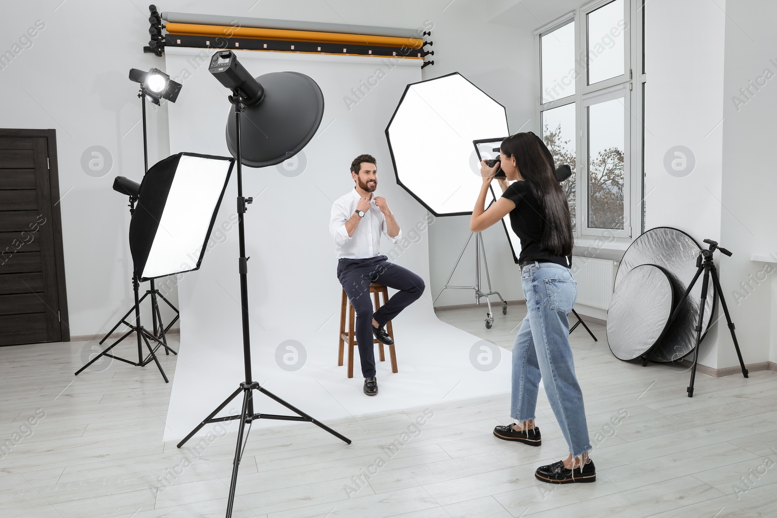 Photo of Handsome model posing for professional photographer in studio