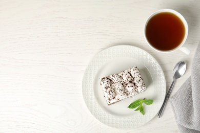 Photo of Flat lay composition with tiramisu cake and cup on white table, space for text