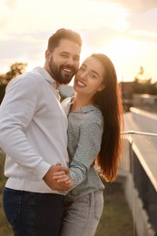 Photo of Lovely couple dancing together outdoors at sunset