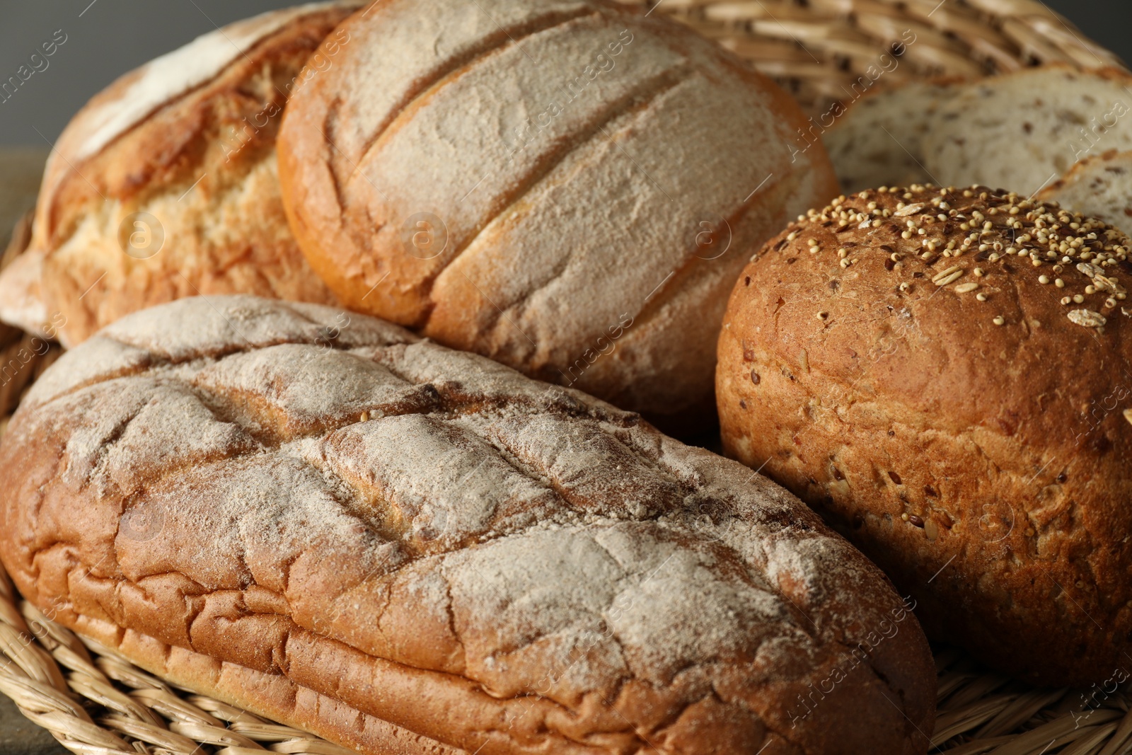 Photo of Basket with different types of fresh bread on table, closeup