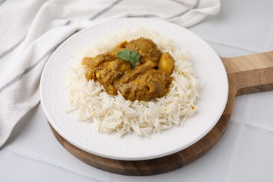 Photo of Delicious chicken curry with rice on white tiled table