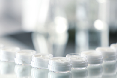 Photo of Small jars with cream in cosmetic laboratory