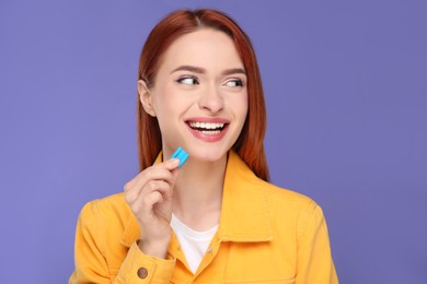Photo of Beautiful woman with bubble gum on purple background