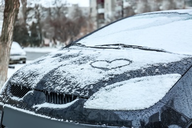 Photo of Heart drawn on car covered with snow outdoors