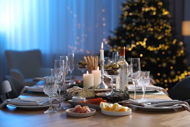 Photo of Christmas table setting with festive decor and dishware in room