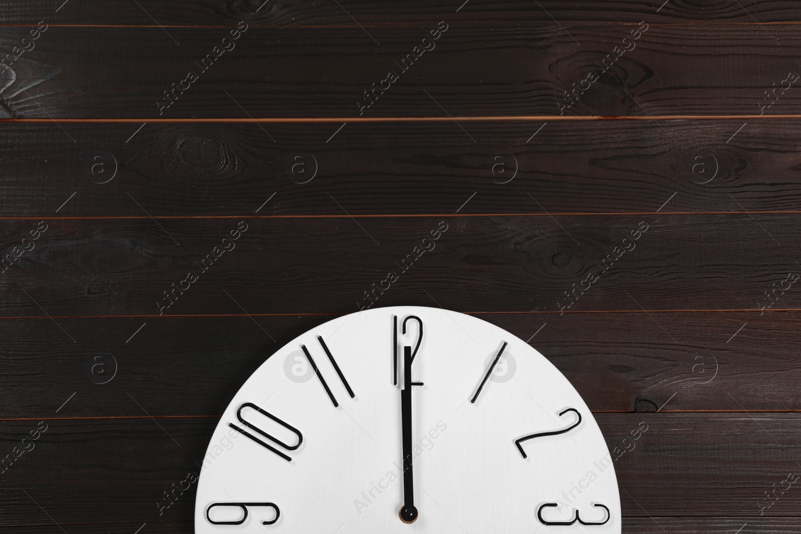 Photo of Stylish analog clock hanging on wooden wall, space for text