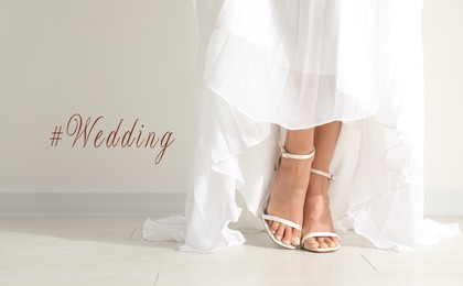 Image of Hashtag Wedding and young bride wearing beautiful dress near light wall, closeup