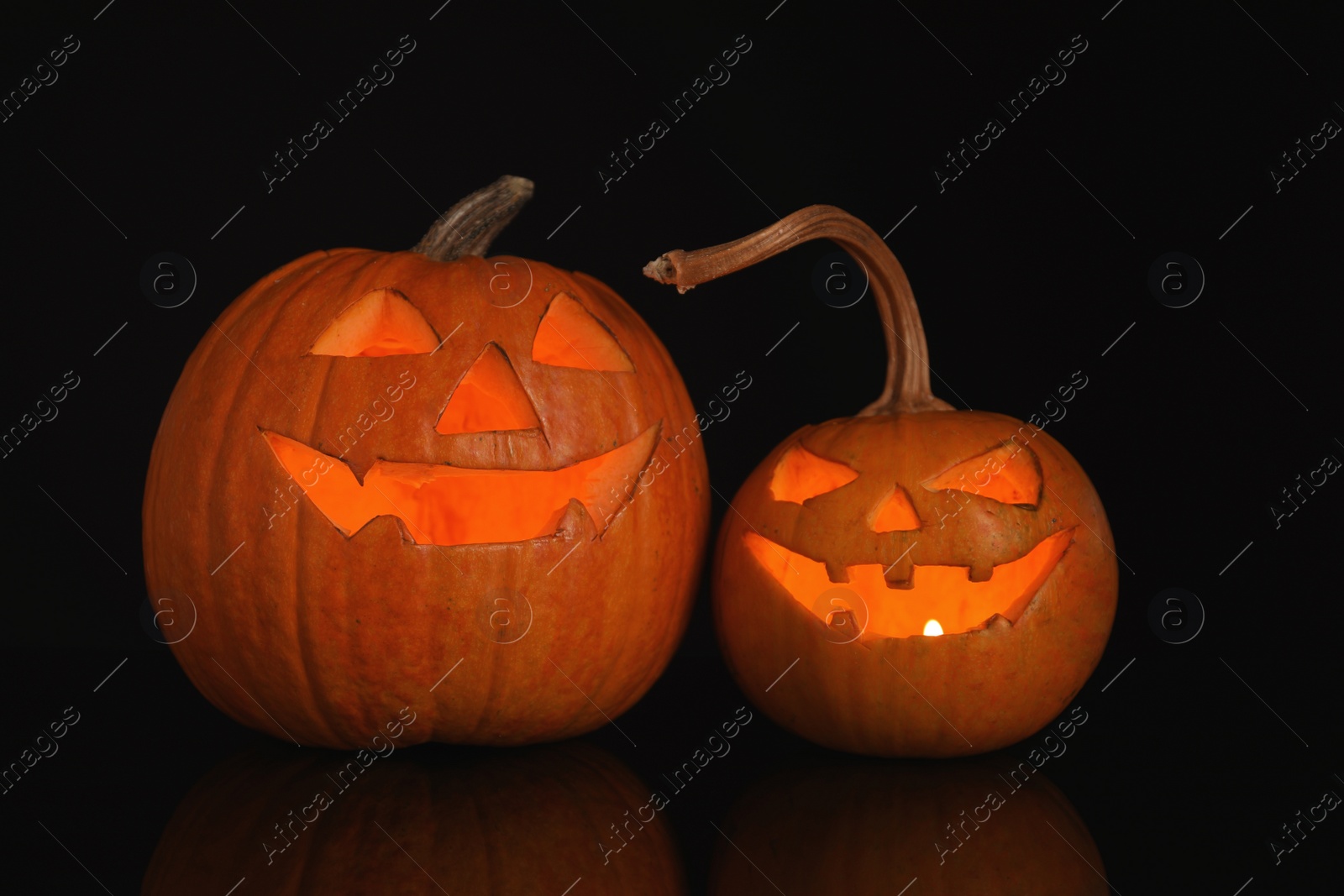 Photo of Halloween pumpkin heads. Glowing jack lanterns on dark background