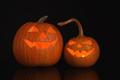 Photo of Halloween pumpkin heads. Glowing jack lanterns on dark background