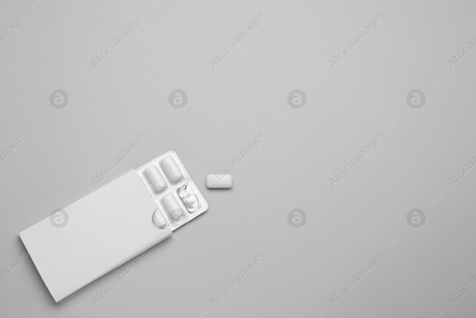 Photo of Blister with chewing gums on grey background, top view. Space for text