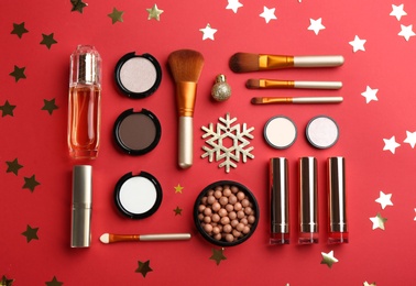 Photo of Flat lay composition with decorative cosmetic products on red background. Winter care