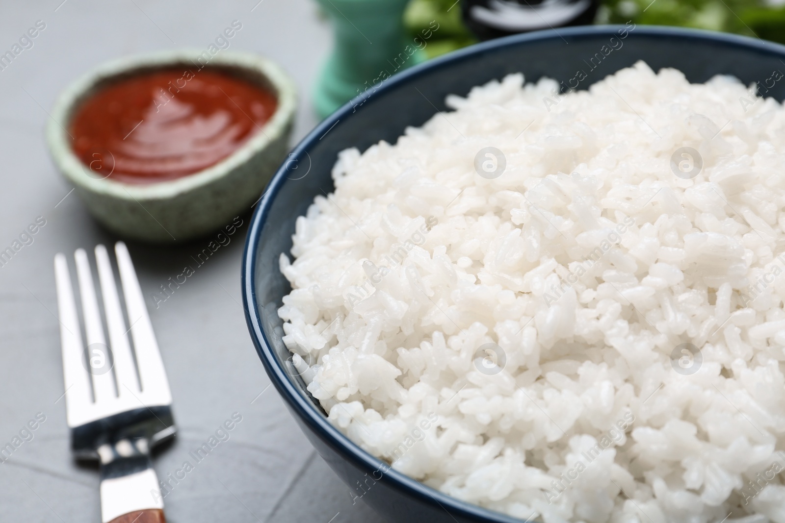 Photo of Bowl of boiled rice on table, closeup