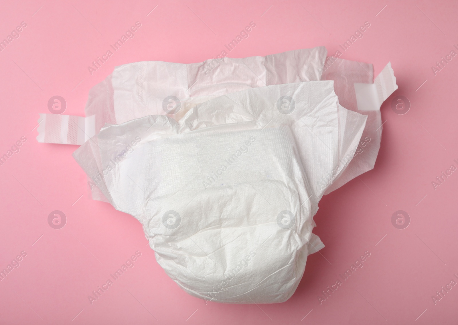 Photo of Baby diaper on pink background, top view