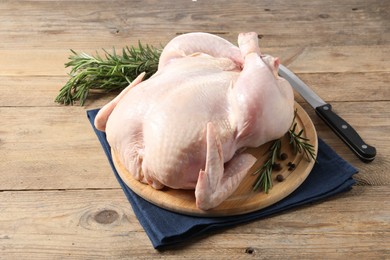 Fresh raw chicken with spices and knife on wooden table